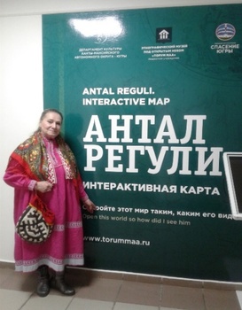 Antal Reguli Interactive Map bemutatása Hagyományos öltözetet viselő személy az Antal Reguli Interactive Map előtt