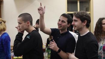 Csoport emberek egy asztal körül italokkal Csoport emberek egy asztal körül, amelyen különféle italok vannak elhelyezve.