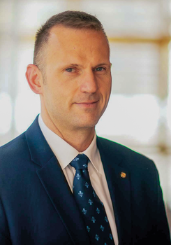 Elegáns férfi kék öltönyben és mintás nyakkendőben Elegáns öltönyben lévő férfi kék mintás nyakkendővel, homályosított arccal