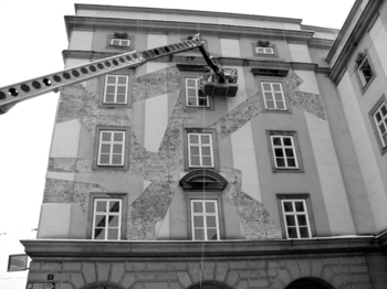 Épület homlokzatának felújítása emelőkosárral Épület homlokzatának felújítása látható, emelőkosaras szerkezettel és ablakokkal.
