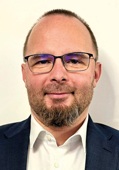 Férfi formális öltözetben fehér inggel és sötétkék zakóval Férfi fehér inget és sötétkék zakót visel, formális öltözetben látható.