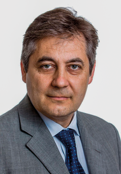 Férfi szürke öltönyben és kék nyakkendőben Férfi szürke öltönyben és kék nyakkendőben, a képen a felsőtest látható