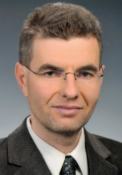 Formális öltözet üzleti viseletben Sötét öltöny, fehér ing és mintás nyakkendő formális öltözetben.