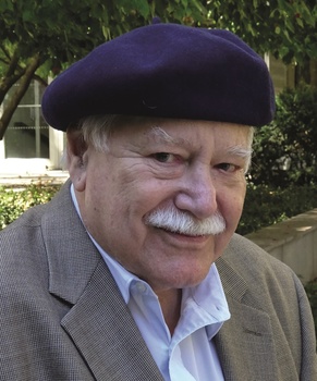 Idős férfi barettben, elegáns öltözetben Idős férfi barettben, elegáns öltözetben, háttérben zöld növények és épület