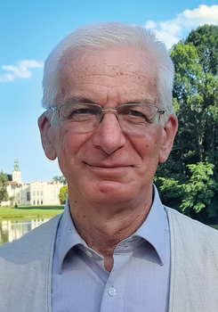 Kastély a tó partján, háttérben fák és kék ég Kastély a tó partján, háttérben fák és kék ég látható a képen.