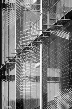 Modern épület üveg homlokzata geometriai mintákkal Modern épület üveg homlokzata geometriai mintákkal, amely stílusos és innovatív megjelenést kölcsönöz.