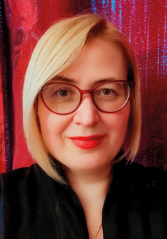 Szőke hajú nő vörös háttér előtt Szőke hajú nő fekete ruhában, vörös háttér előtt