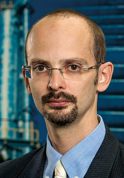 Üzletember öltönyben modern épület háttérben Üzletember öltönyben és nyakkendőben, háttérben egy modern épület látható